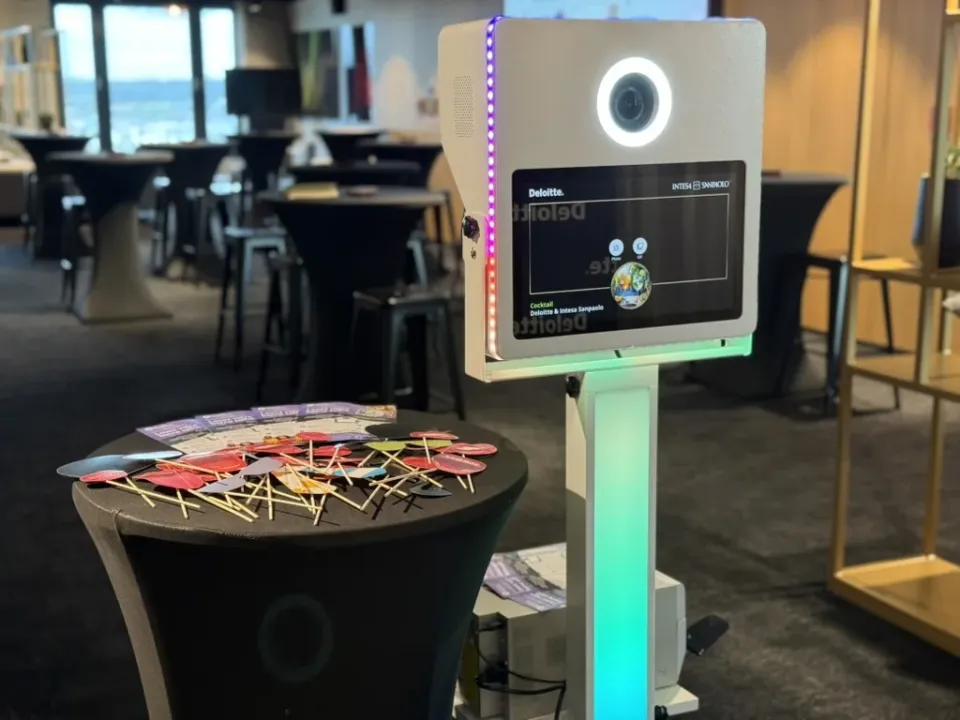 Borne lumineuse à un cocktail d'entreprise : écran d'accueil à la marque, accessoires en carton sur un mange-debout
