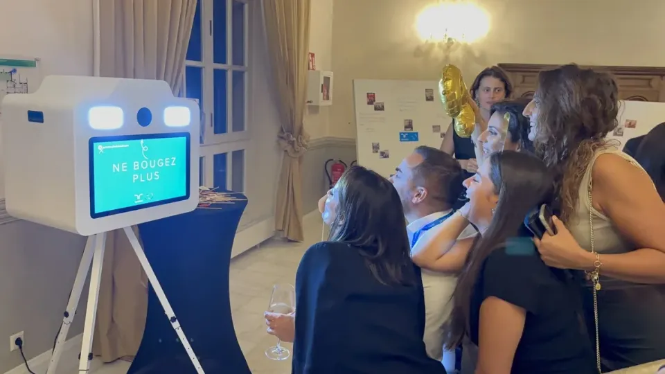Invités qui rient devant l'écran « Ne bougez plus » de la borne, juste avant la photo