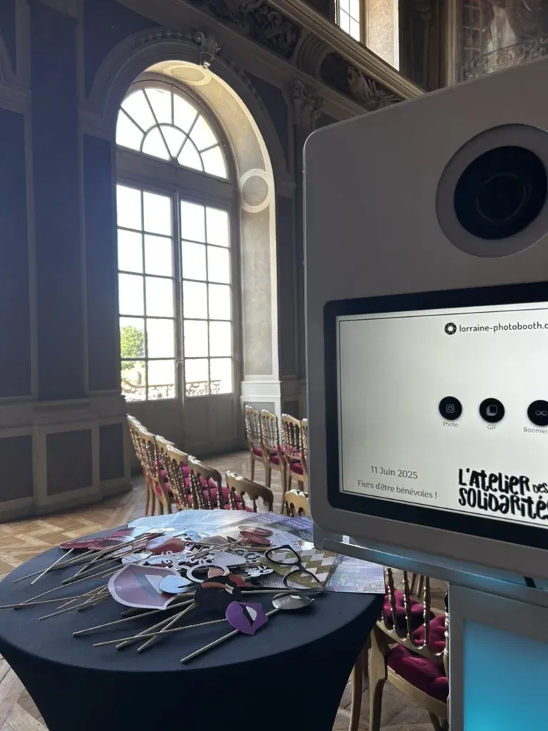 La borne lumineuse de près : objectif du reflex, écran tactile personnalisé et accessoires, dans une salle classée