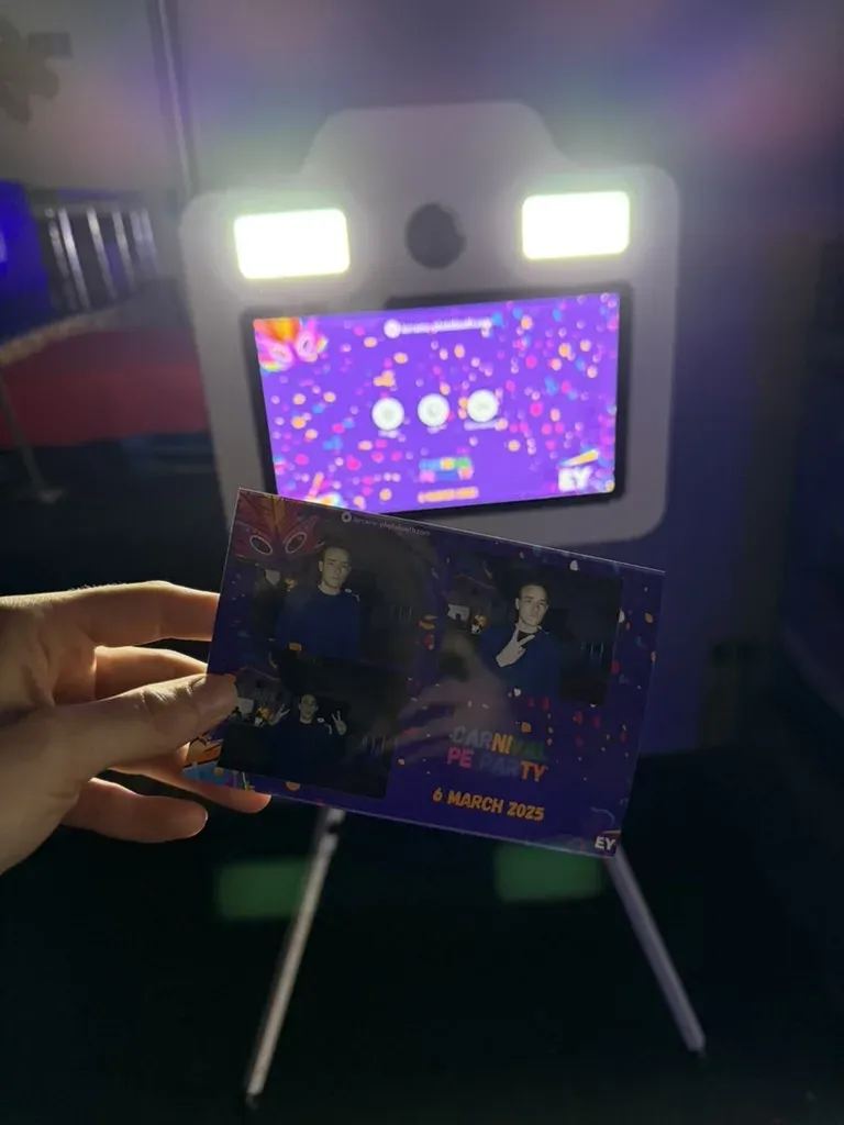 Tirage photobooth au cadre carnaval tenu devant la borne